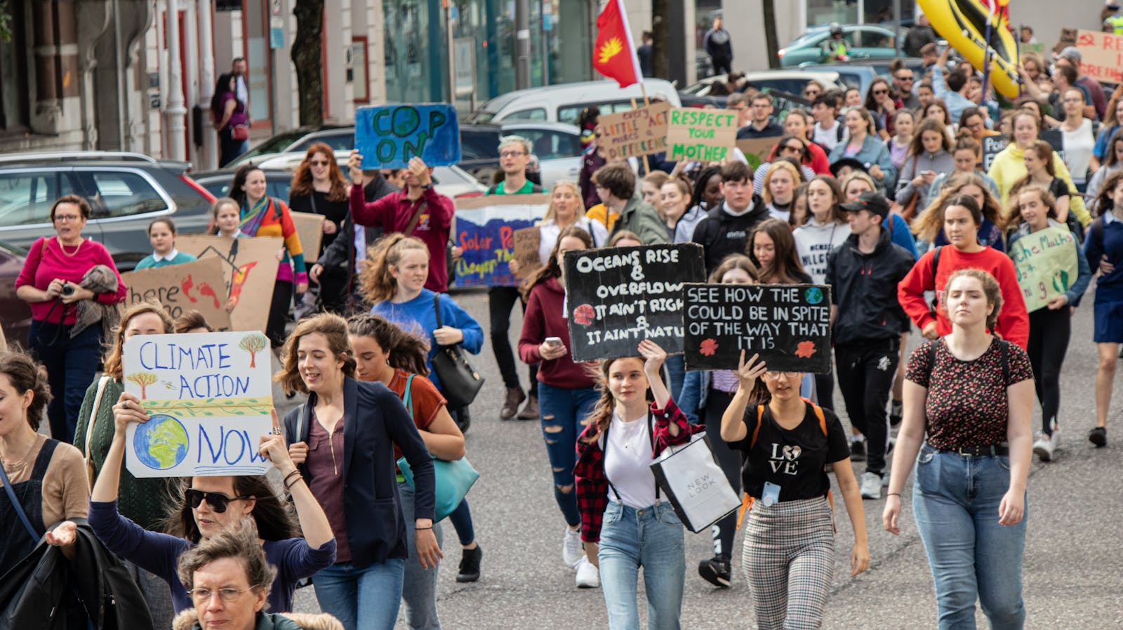 A vibrant climate march with diverse group holding signs demanding climate action. cop30.